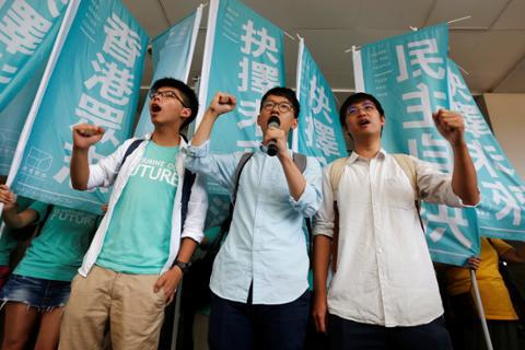 Student leaders Joshua Wong, Nathan Law, and Alex Chow chant slogans before their verdict outside the courthouse in Hong Kong on July 21, 2016.
