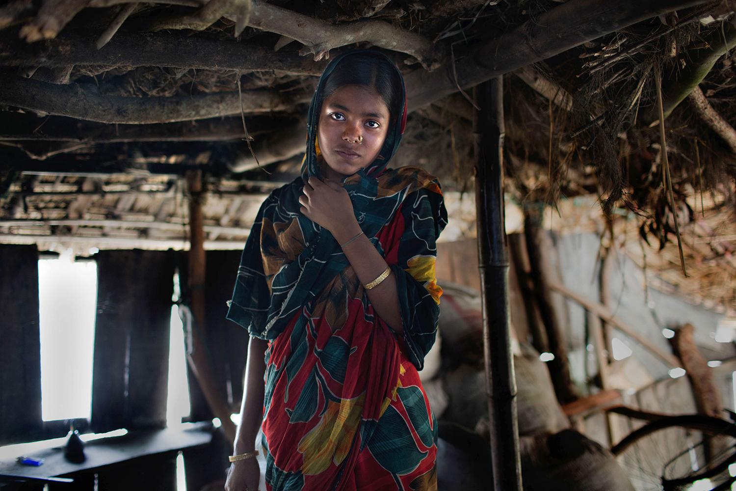 Thirteen-year-old Sifola in the home she shares with her husband and in-laws in Bangladesh. Sifola’s parents, struggling with poverty, took her out of school and arranged for her marriage so that the money saved could pay for her brothers’ schooling. © 20