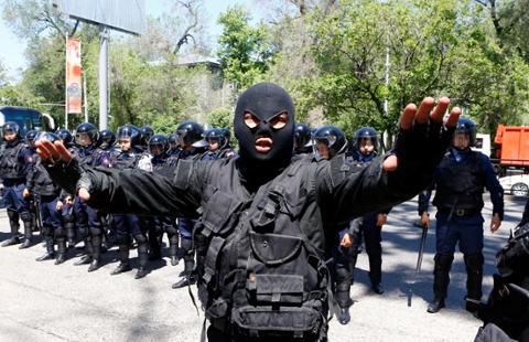 Riot police officer gestures during protests in Almaty, Kazakhstan on May 21, 2016.