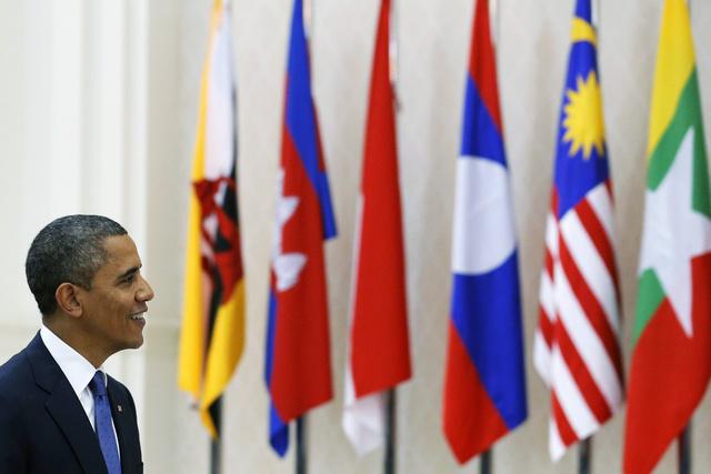 U.S. President Barack Obama passes in front of ASEAN members flags as he arrives for the Plenary session of the 21st ASEAN (Association of Southeast Asian Nations) and East Asia summits in Phnom Penh