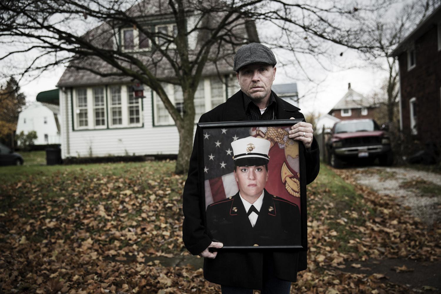 Gary Noling holding a photo of his daughter Carri Goodwin, a rape victim who died of acute alcohol intoxication less than a week after receiving an Other Than Honorable discharge from the Marines.