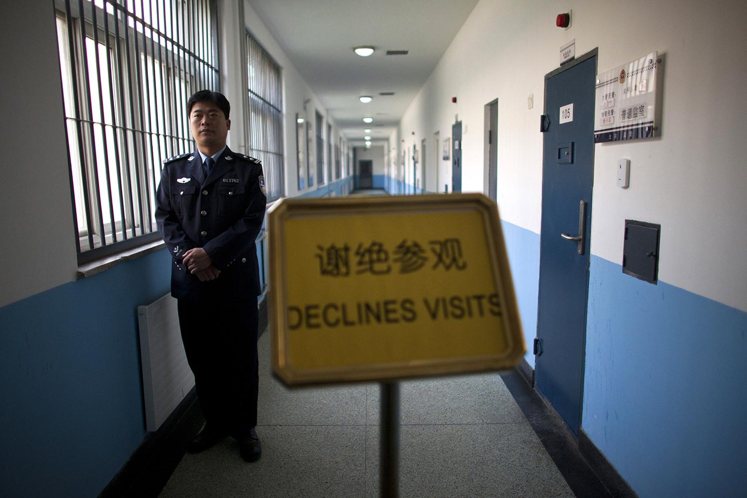 一名民警守在走廊，不准由官方组织来参访北京市第一看守所的新闻记者进入。2012年10月25日