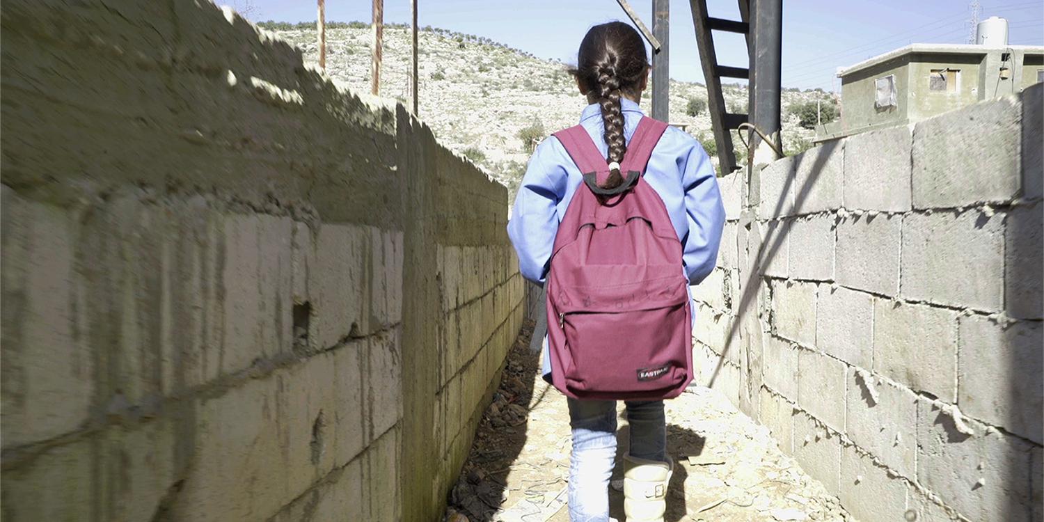 براءة (10 أعوام)، من الغوطة بسوريا، ذاهبة إلى المدرسة من مخيمها غير الرسمي في جبل لبنان.