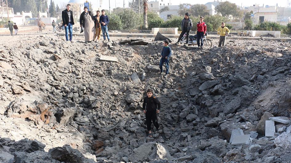 Un jeune garçon marche parmi les débris dans un cratère résultant, selon des activistes locaux, de l’impact d’un missile balistique ayant frappé ce quartier d’Azaz, en Syrie, en février 2016.