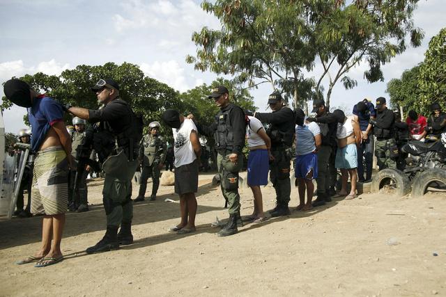 Militares venezolanos detienen a hombres que supuestamente tendrían vínculos con un grupo paramilitar durante una redada de la OLP en el estado de Táchira, Venezuela.