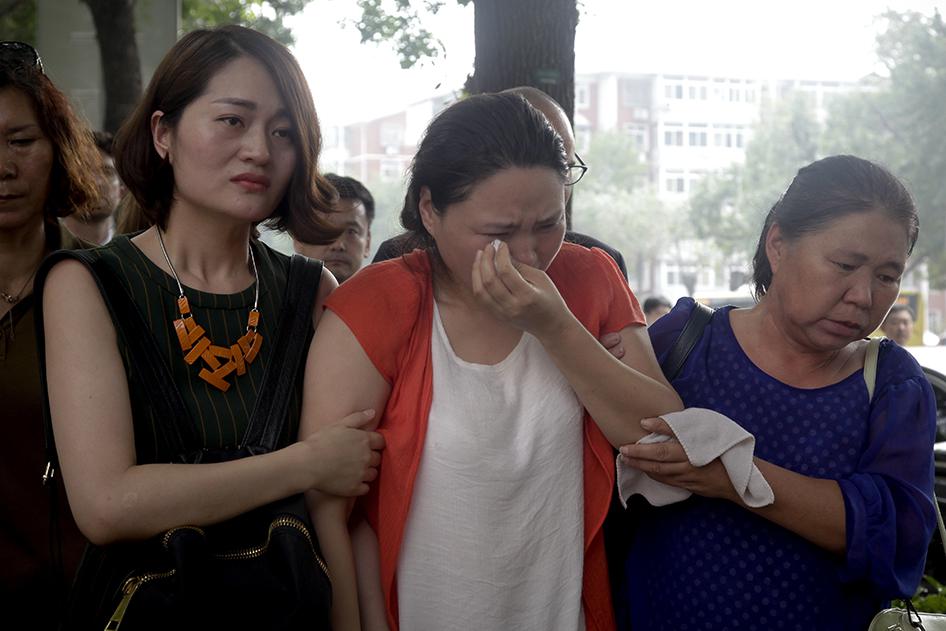 在押维权人士勾洪国之妻樊丽丽（中）和在押律师王全章之妻李文足（左）及另一妇女在天津市第二中级人民法院外抗议，2016年8月1日星期一摄于中国天津 。