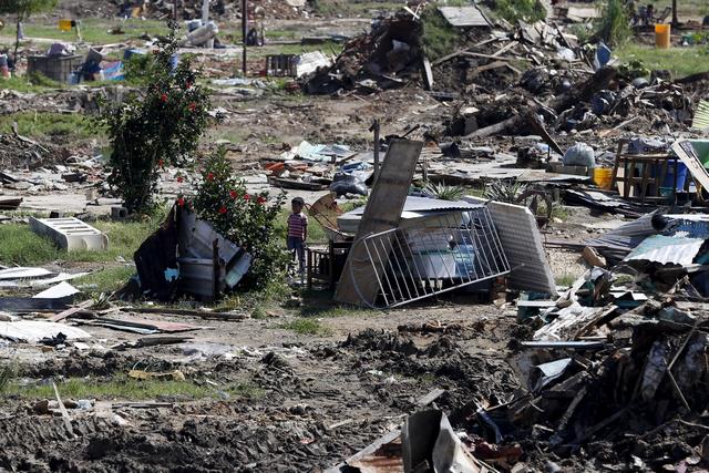 Un niño se encuentra junto a las ruinas de casas que fueron demolidas por autoridades durante un operativo de seguridad en el marco de la "Operación de Liberación y Protección del Pueblo " (OLP) en Valencia. © 2015 Reuters