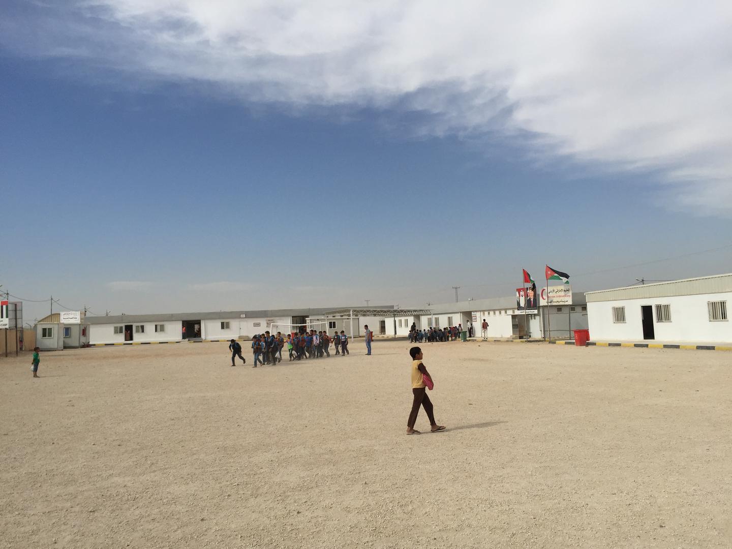 أطفال سوريون يخرجون من المدرسة في المخيم الإماراتي الأردني، شمالي الأردن، 21 أكتوبر/تشرين الأول 2015. تُشغّل وزارة التربية والتعليم الأردنية المدارس في مخيمات اللاجئين، وتمدها بمعلمين وإداريين. بيل فان إسفلد/هيومن رايتس ووتش 