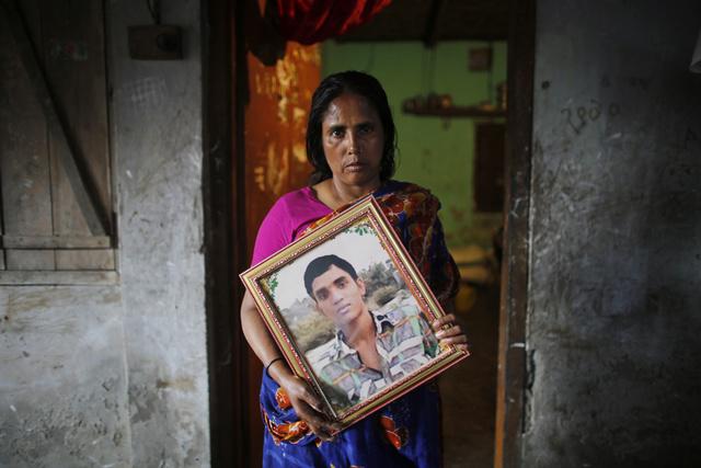 Fatema holds a picture of her son Nurul Karim, one year after both he and her daughter Arifa died in the April 24, 2013 Rana Plaza collapse.