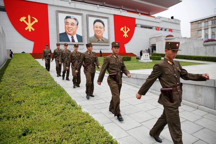 Soldiers walk under pictures of former North Korean leaders Kim Il Sung and Kim Jong Il at the capital's main ceremonial square after a mass rally and parade on May 10, 2016.