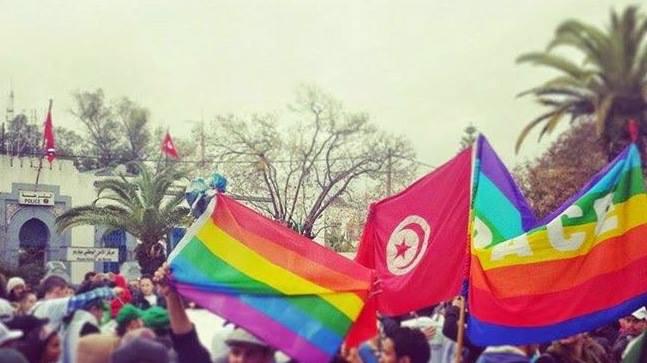متظاهرون يرفعون أعلاما تونسية وعلما بألوان قوس قزح أثناء مسيرة ضدّ الإرهاب على هامش المنتدى الاجتماعي العالمي – تونس، مارس 2015.