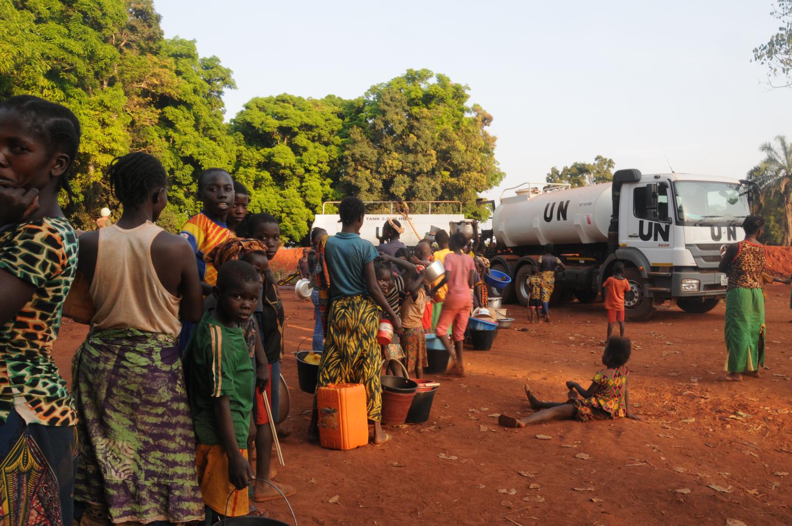 People dispaced from the fighting in Bria wait for water at a makeshift camp in town on November 28, 2016.