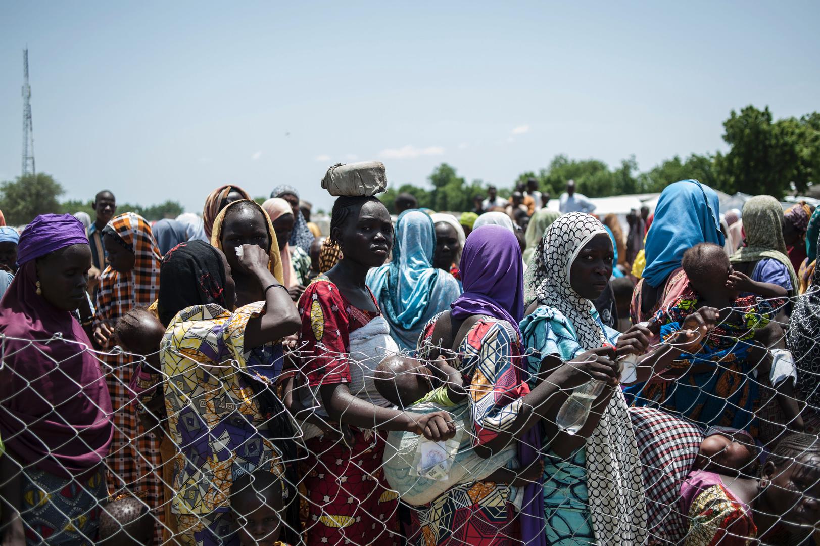 Women and children queue on September 15, 2016 to enter a nutrition clinic at an informal settlement in the outskirts of Maiduguri, the capital of Borno State, in northeastern Nigeria.
