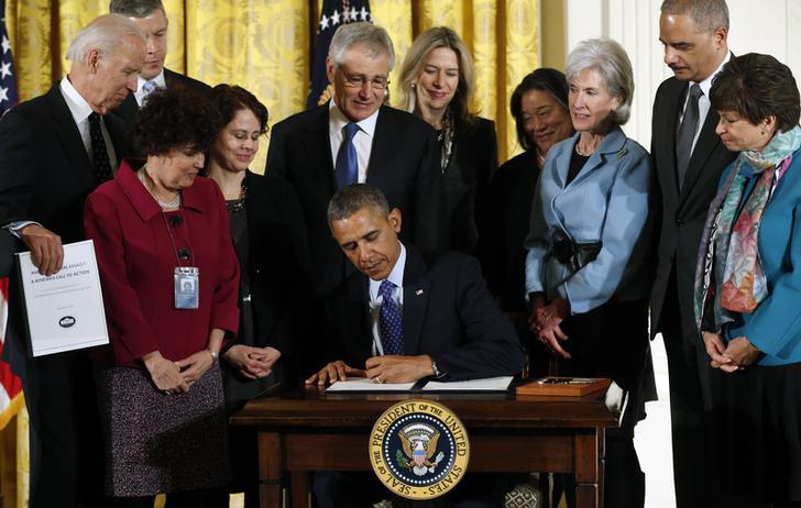 President Barack Obama signs a presidential memorandum establishing a White House Task Force on Protecting Students from Sexual Assault during an event for the Council on Women and Girls.