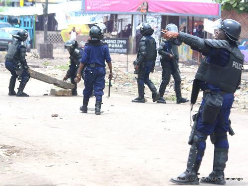 Des policiers dégagent une route après que des manifestants aient dressé des barricades, le 19 septembre 2016 à Kinshasa.