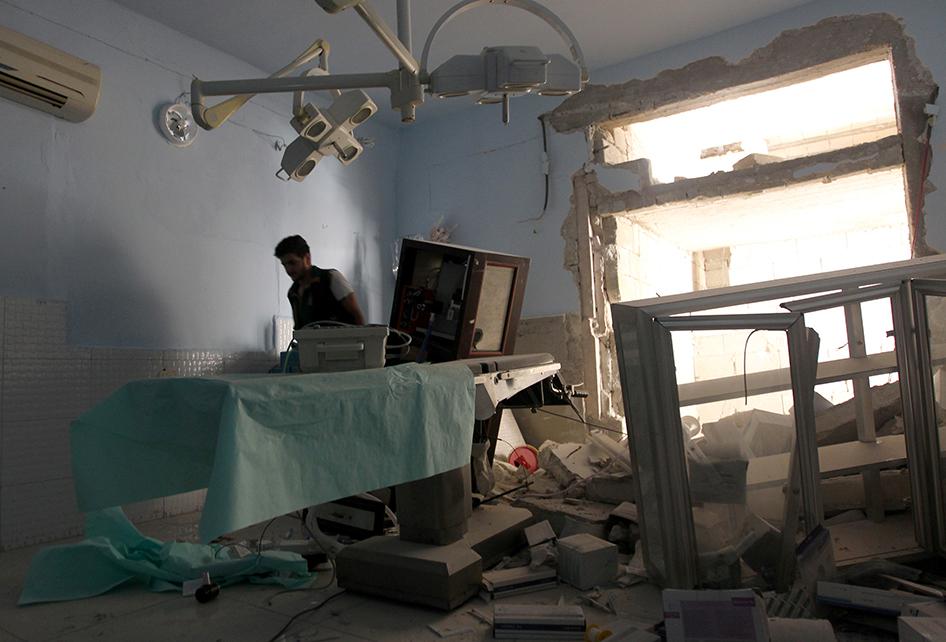 A medic inspects the damage inside Anadan Hospital, sponsored by Union of Medical Care and Relief Organizations (UOSSM), after it was hit by an airstrike in the rebel held city of Anadan, northern Aleppo province, Syria on July 31, 2016. 