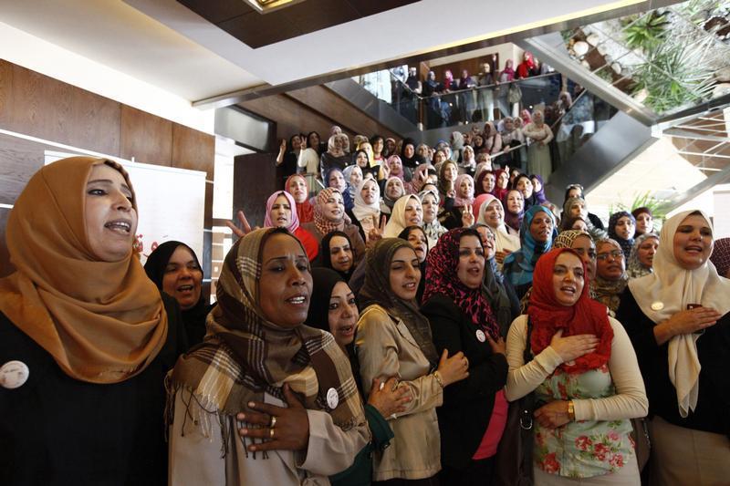 Women candidates sing the national anthem before taking a group photo at a conference to empower women voters and politicians in Tripoli June 25, 2012.