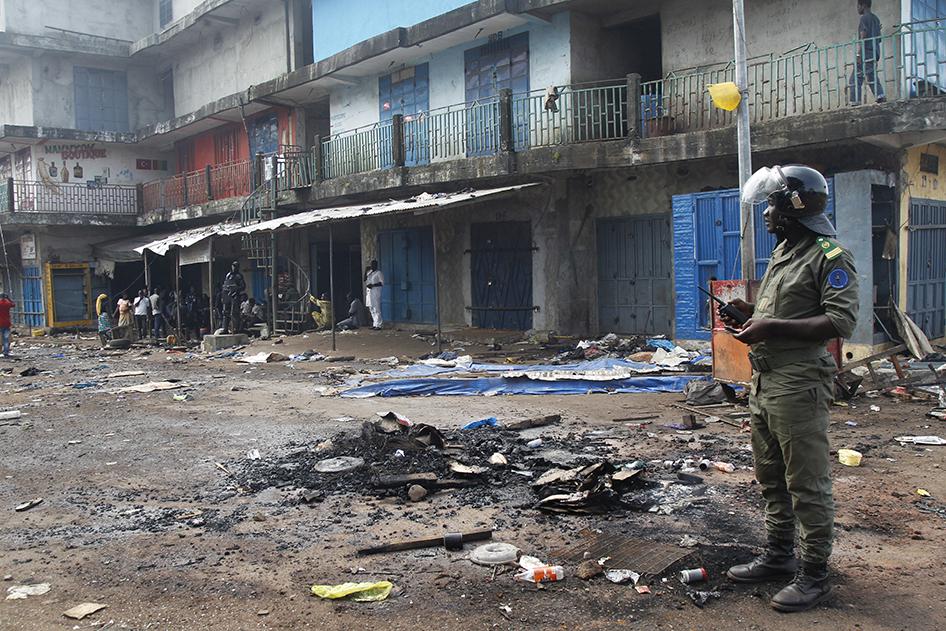 Un agent de sécurité guinéen parmi les décombres du marché de Madina à Conakry, en Guinée, le 9 octobre 2015, à la suite d'affrontements entre des membres de partis politiques rivaux à l’avant-veille du scrutin présidentiel.