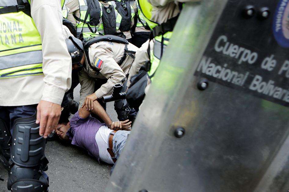 Riot police officers detain a demonstrator during clashes with opposition supporters in a rally to demand a referendum to remove President Nicolás Maduro in Caracas, Venezuela, on May 18, 2016. 