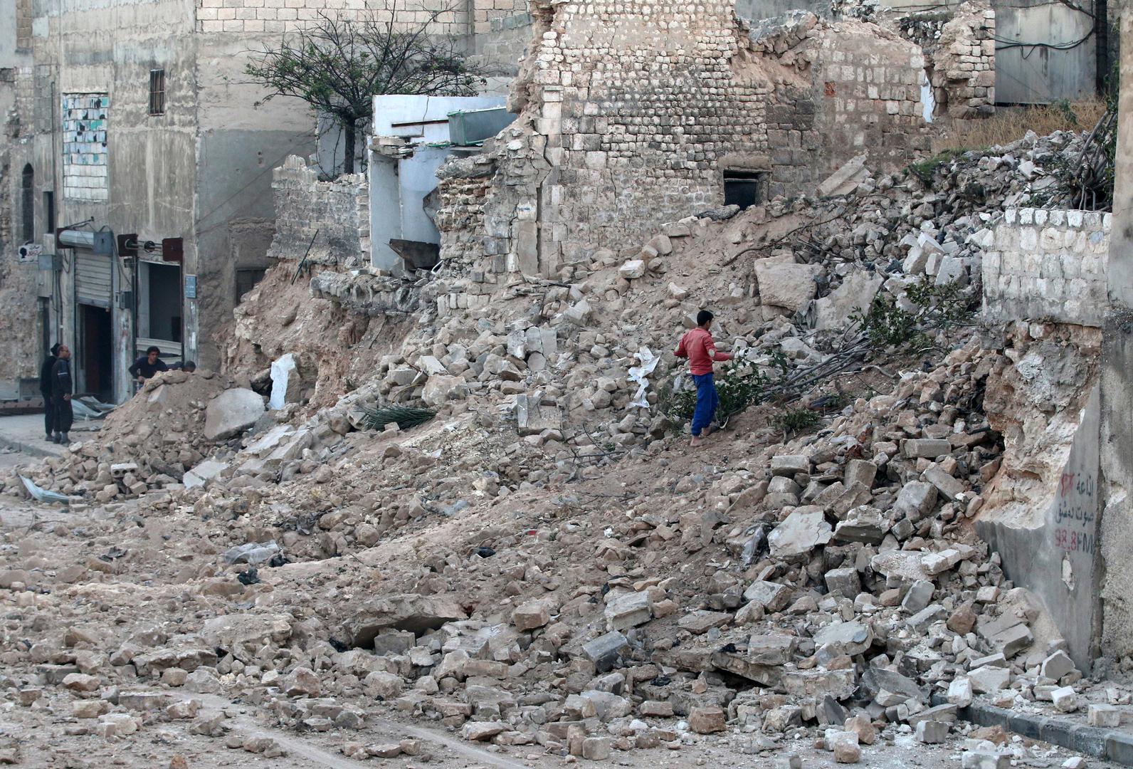 Un habitant d’Alep parmi les décombres d'un immeuble endommagé dans le quartier assiégé de Qadi Askar de cette ville en Syrie.