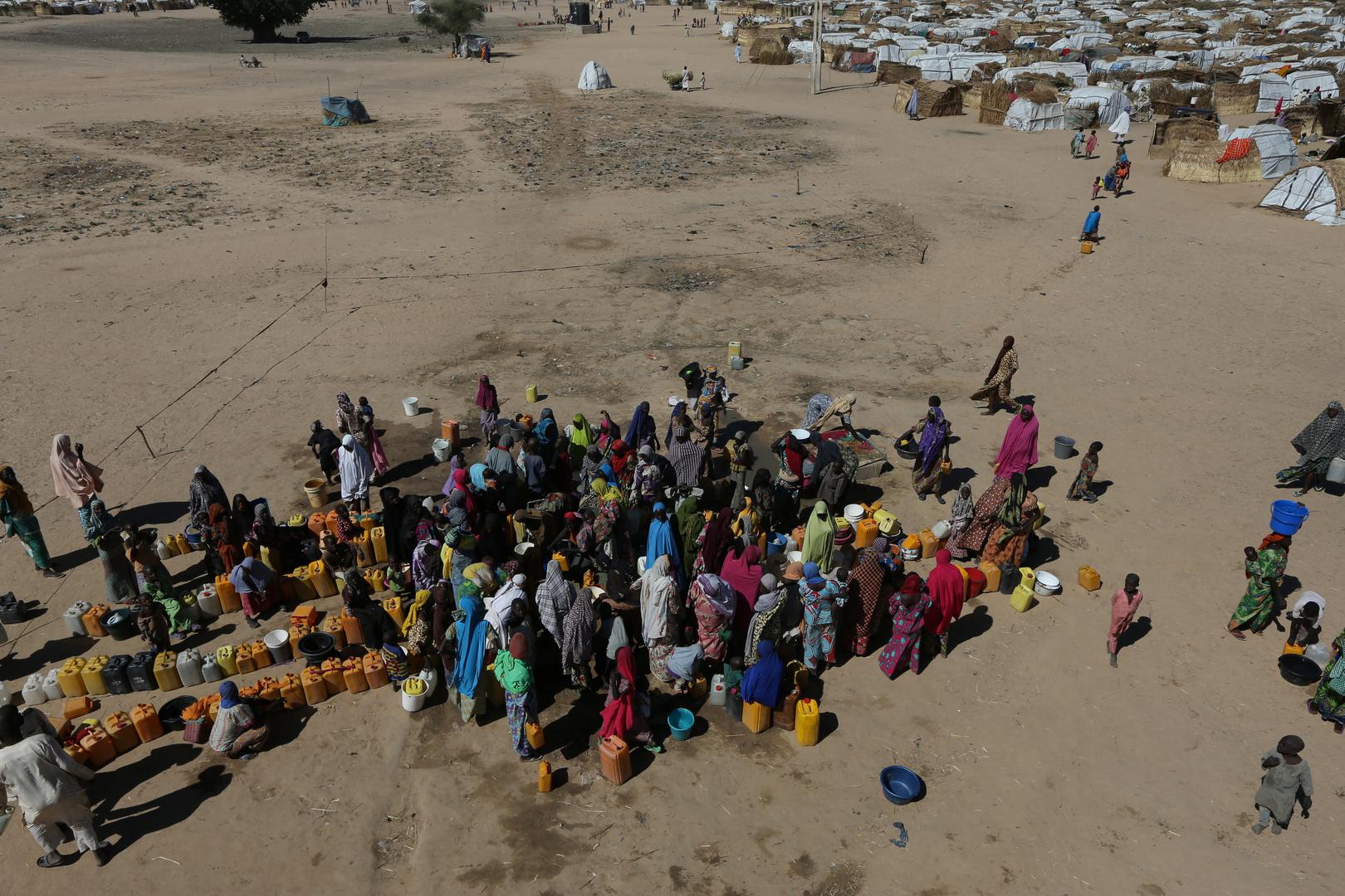 Women and children gather at the water point at an internally displaced people’s camp in Maiduguri