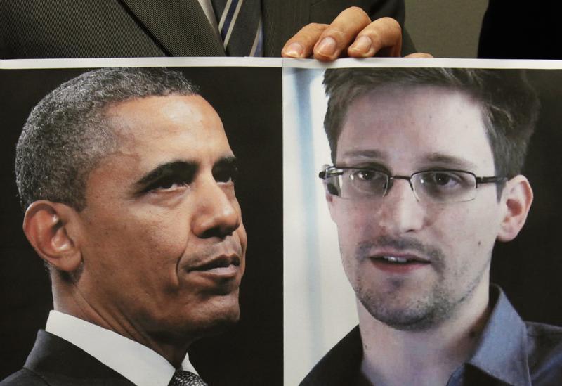 A supporter of Edward Snowden holds a combination photo featuring U.S. President Barack Obama and Edward Snowden, during a news conference in Hong Kong on June 14, 2013.