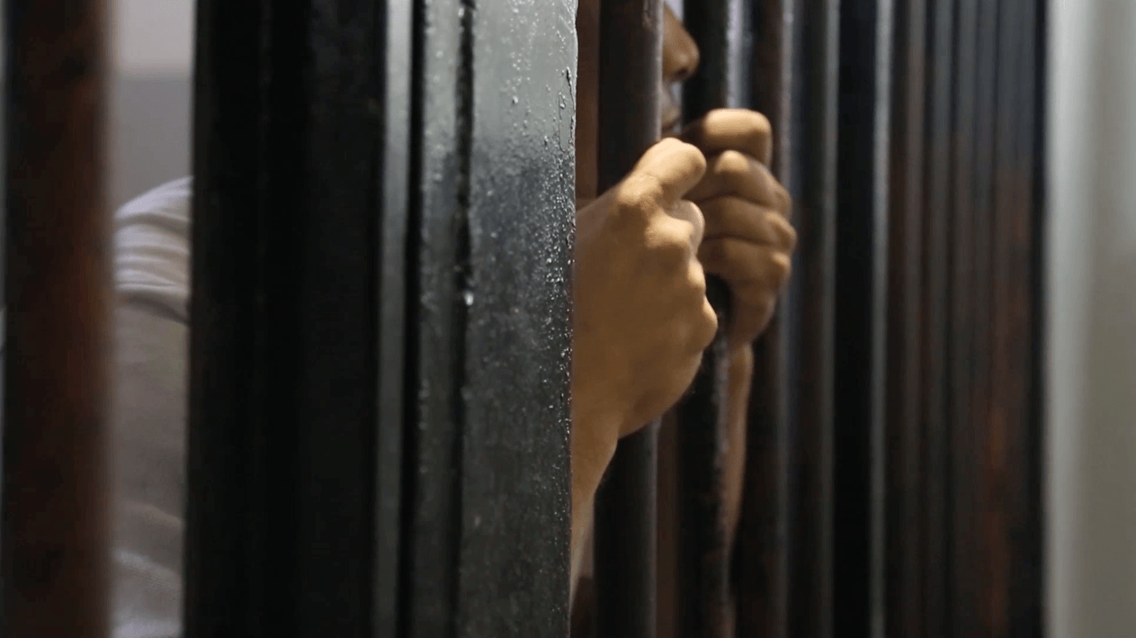 Un homme incarcéré dans le centre de détention de Sfax, en Tunisie, s'agrippe aux barreaux de sa cellule, le 26 septembre 2013.