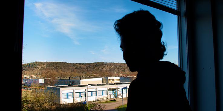 Tekle S., a 16-year-old Eritrean boy, looking out a window in his group home in Gothenburg, Sweden. 