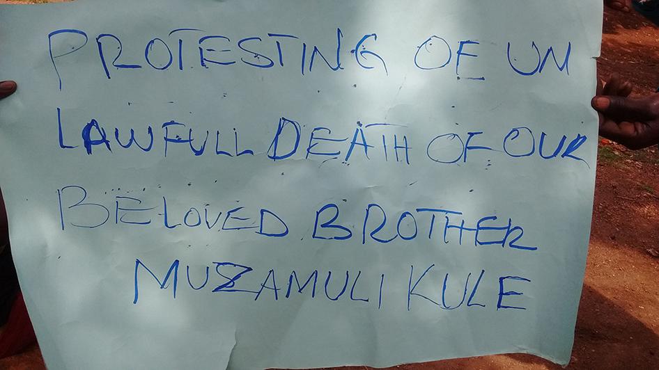 A protestor holding a poster held in memory of Kule Munyambara Obed, who was allegedly shot by the Ugandan military in Kasese district on April 3, 2016.