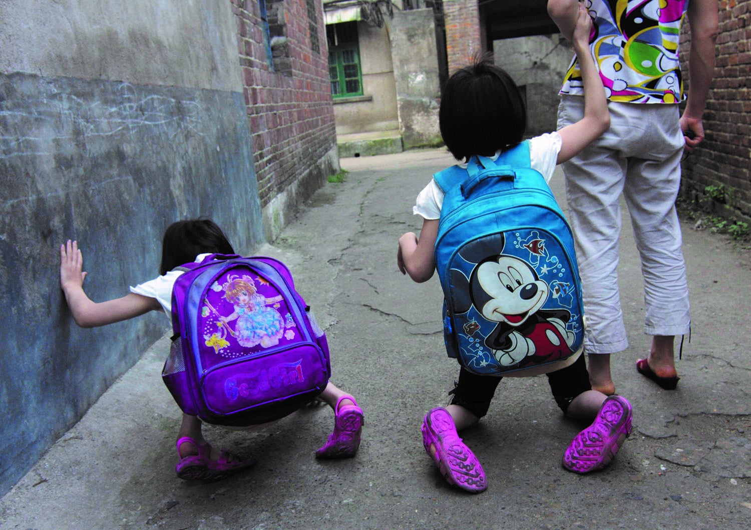 Twin sisters with mobility disabilities making their way to school.