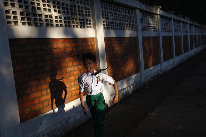 A boy runs as he exits his school in Yangon, November 6, 2013. 