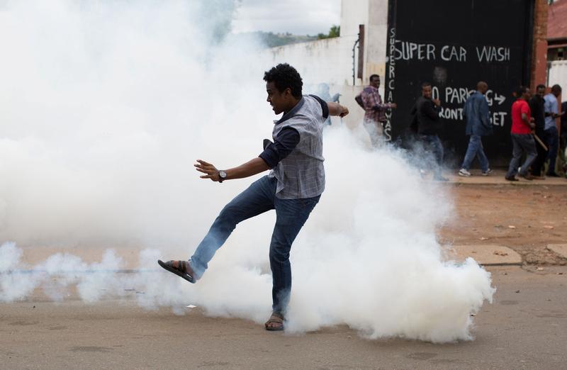 A man reacts to tear gas fired by police fire to disperse rival marches by hundreds of protesters, after mobs looted stores this week believed to belong to immigrants in Pretoria, South Africa, February 24, 2017.