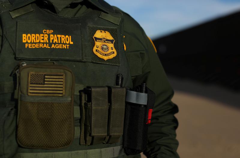 A U.S. border patrol agent walks along the border fence separating Mexico from the United States near Calexico, California, U.S. February 8, 2017.