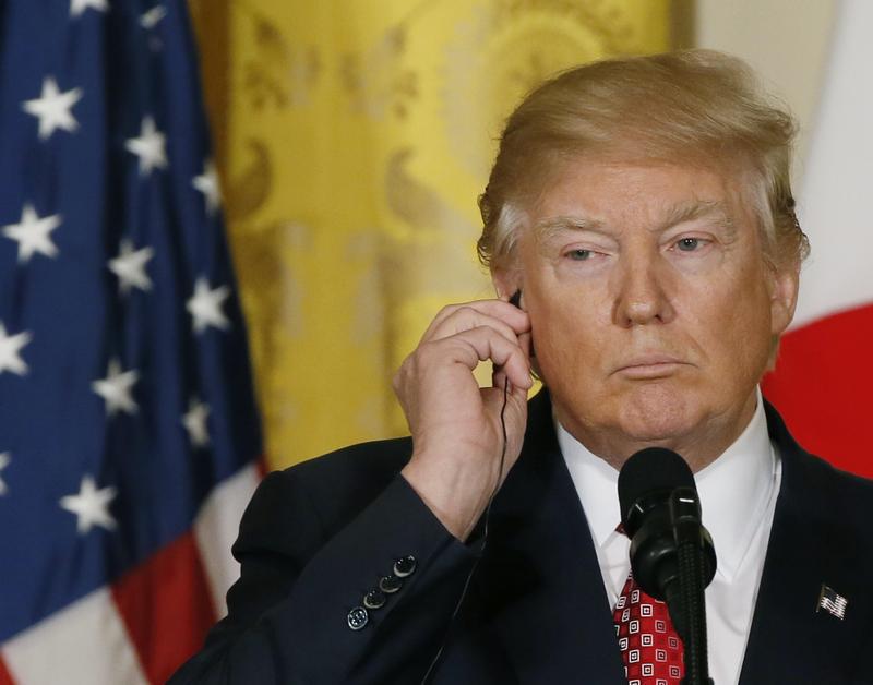 U.S. President Donald Trump holds his earpiece as he holds a joint press conference with Japanese Prime Minister Shinzo Abe (not pictured) at the White House in Washington, U.S., February 10, 2017.