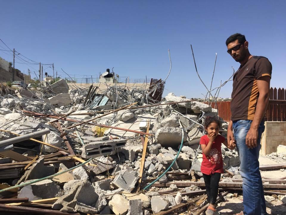אשרף פוואקה ובתו סאבא עומדים ב-15 במאי 2017 ליד חורבות ביתם במזרח ירושלים, שנהרס בידי הרשויות הישראליות ב-4 במאי בעילה של בנייה ללא רישיון.  