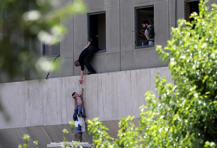 پسري در حال تخليه شدن در حين حمله به مجلس ايران در  مركز شهر تهران، ايران، ٧ جون٢٠١٧.
