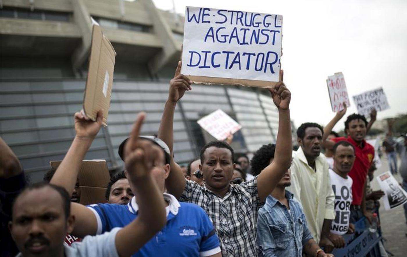 Eritrean refugees hold placards during a protest against the Eritrean government outside their embassy in Tel Aviv, Israel May 11, 2015.