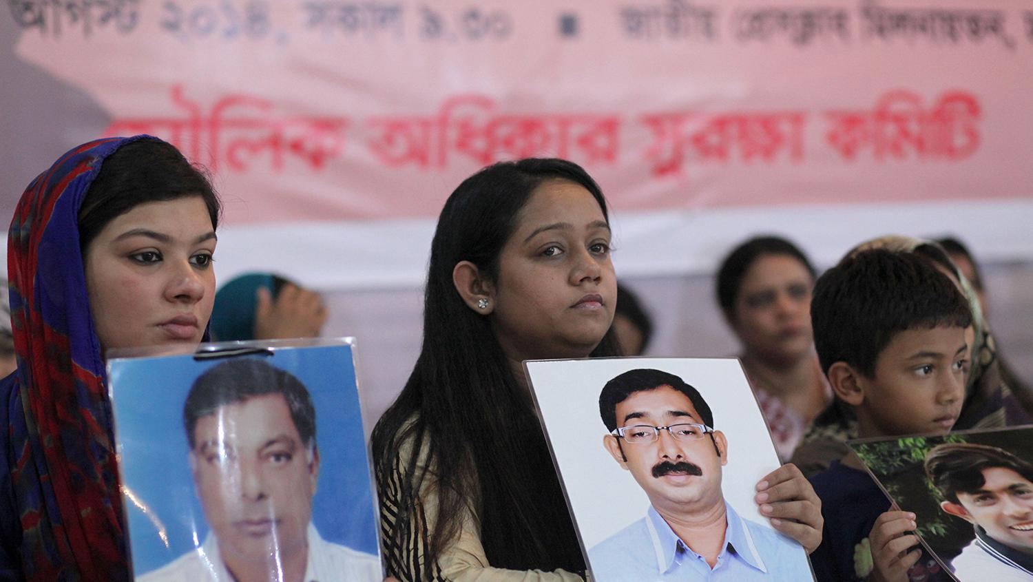 আত্মীয়রা পরিবারের নিখোঁজ হওয়া সদস্যদের ছবি ধরে আছেন জোরপূর্বক নিখোঁজ, হত্যা এবং অপহরণ বন্ধের জন্য আয়োজিত একটি অনুষ্ঠানে, ঢাকা, বাংলাদেশ, ৩০শে অগাস্ট, ২০১৪ 