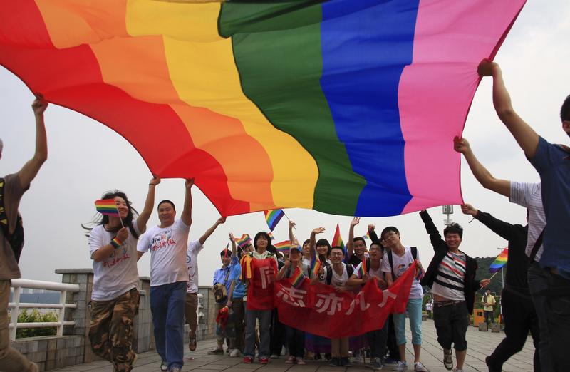 2013年5月17日，湖南省长沙市国际反恐同日游行上民众高举彩虹旗。
