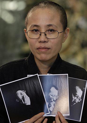 La poétesse Liu Xia tient des photos de son mari emprisonné, le dissident chinois Liu Xiaobo, en 2013. Liu Xiaobo, prix Nobel de la paix 2010, est décédé le 13 juillet 2017.