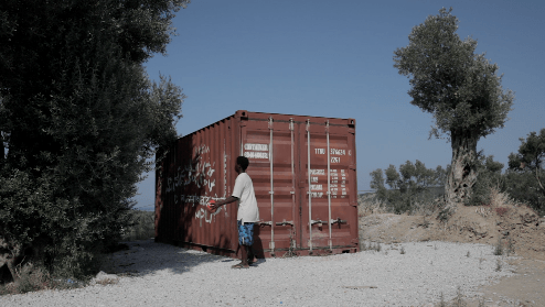 “Amadou,” a 16-year-old unaccompanied boy from West Africa playing with a soccer ball in front of a container on Lesbos, Greece. Amadou, on Lesbos since October 2016, said the lack of adequate information and fear of detention, made him register as an adu
