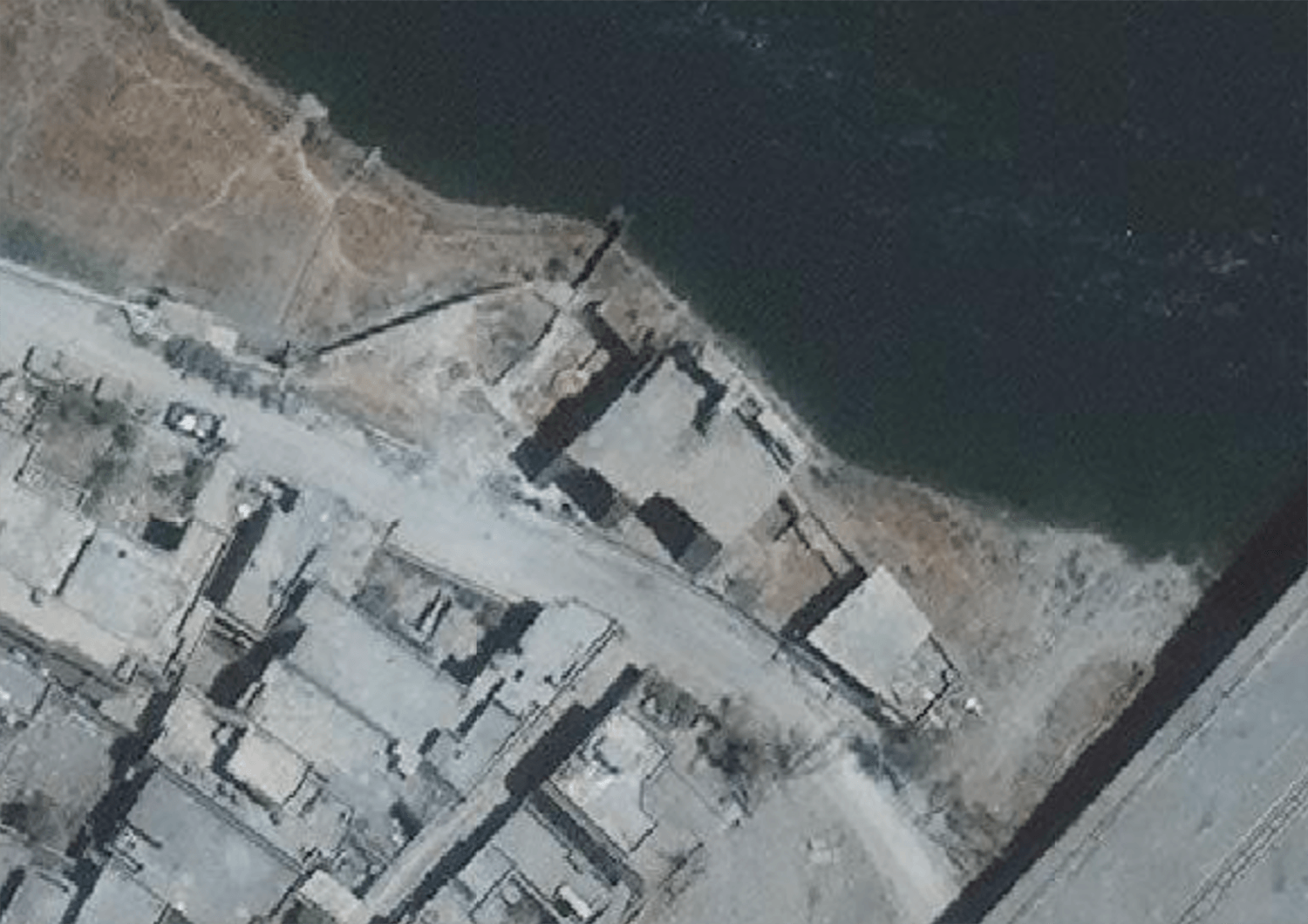 Satellite imagery from July 12 showing the building and Tigris riverbank seen in a video posted of soldiers throwing a detainee off a cliff in west Mosul as well as military vehicles in the vicinity. 