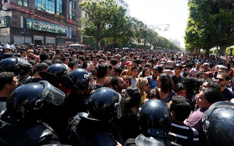 Sur l’avenue Habib Bourguiba, à Tunis, des manifestants brandissent des fusées éclairantes, lors d’une marche contre un projet de loi destiné à protéger de poursuites judiciaires les responsables de corruption. 13 mai 2017. 