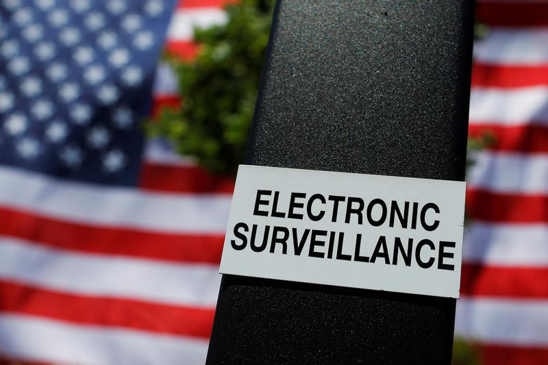 A notice of electronic surveillance is posted near a 95-by-50-foot American flag unfurled on the side of an apartment complex in Manchester, New Hampshire, U.S., June 14, 2017. 