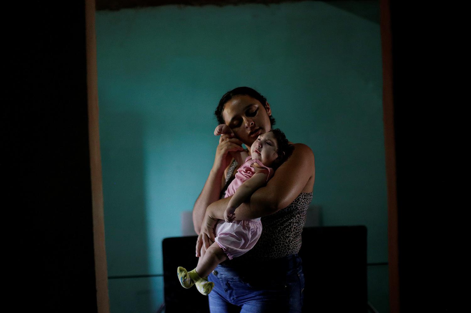 Raquel, 25, com sua filha Heloisa, no município de Areia, no estado da Paraíba, no Brasil. Raquel deu à luz filhas gêmeas com síndrome de Zika em abril de 2016. 