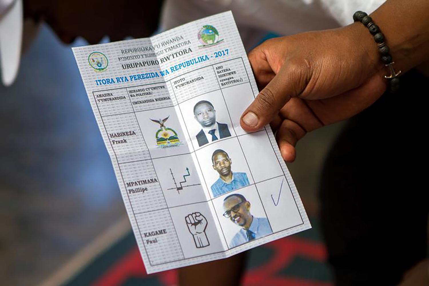 A polling staff member displays a ballot at a polling center in Kigali, Rwanda, August 4, 2017. 