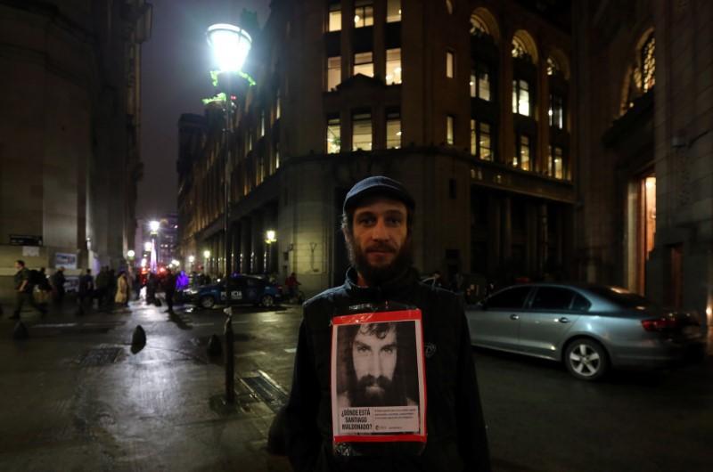  Un hombre posa con un retrato de Santiago Maldonado, durante una manifestación para demandar que el gobierno tome acciones eficaces para encontrarlo, en Buenos Aires, Argentina, 11 de agosto de 2017.  