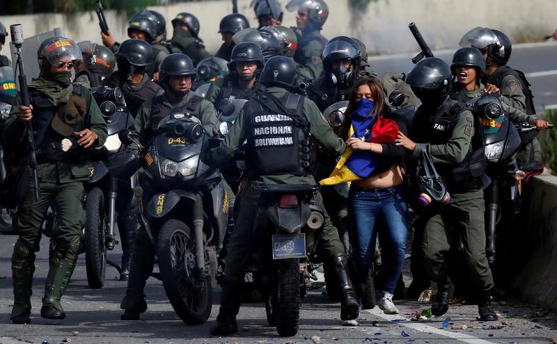 Una manifestante es detenida por fuerzas de seguridad durante una protesta contra el gobierno del Presidente Nicolás Maduro en Caracas, Venezuela, el 10 de julio de 2017. 