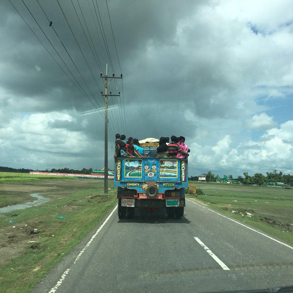 A truck of newly arrived Rohingya refugees is driven to camps already housing over half a million new arrivals. Smoke is seen rising from burning villages in Burma nearby. 