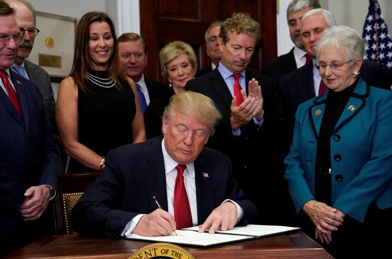 U.S. Senator Rand Paul (R-KY) applauds as U.S. President Donald Trump signs an executive order to make it easier for Americans to buy bare-bones health insurance plans and circumvent Obamacare rules at the White House in Washington, U.S., October 12, 2017